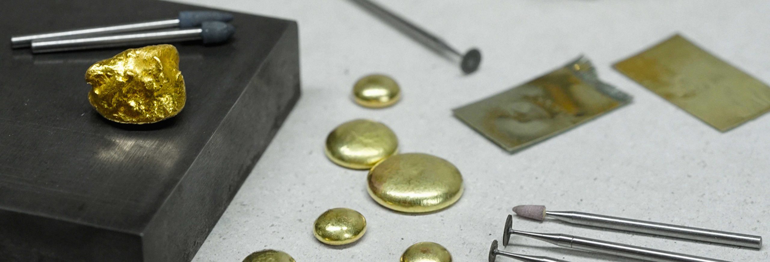 Gold and traditional jewellery-making tools on a London jeweller's workbench